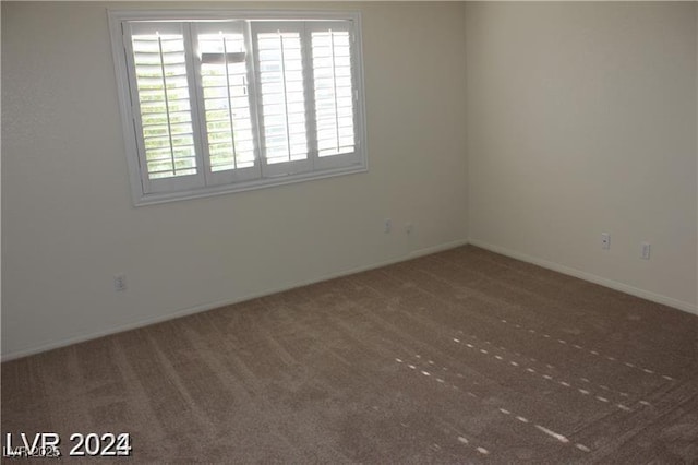 spare room featuring baseboards and carpet flooring