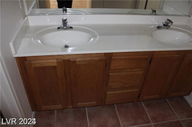 bathroom with tile patterned flooring, a sink, and double vanity