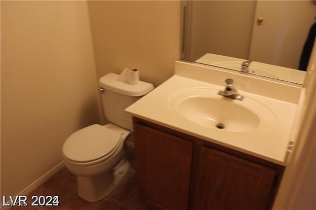 half bath featuring tile patterned flooring, toilet, and vanity