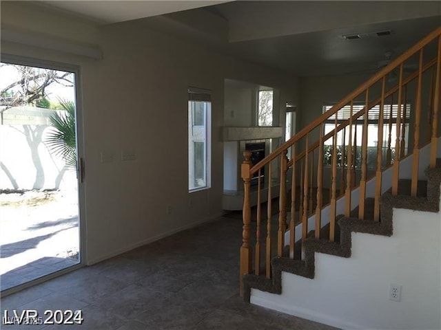 stairway with visible vents, baseboards, and a fireplace