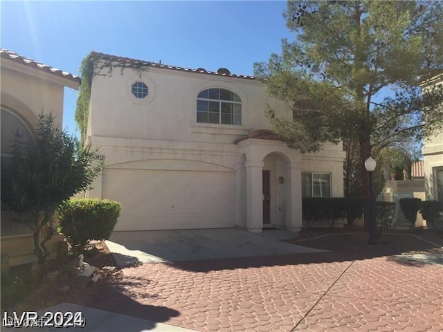 mediterranean / spanish-style home with stucco siding, driveway, and a garage