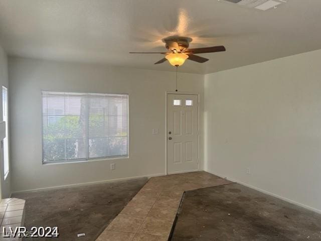 entryway with tile patterned flooring, visible vents, a ceiling fan, and baseboards