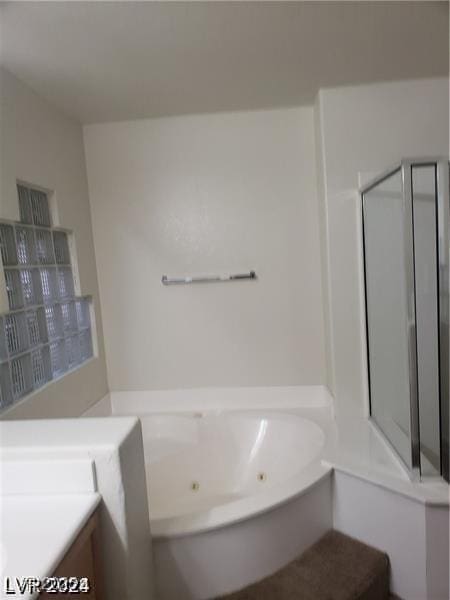 full bathroom with a jetted tub, vanity, and a stall shower