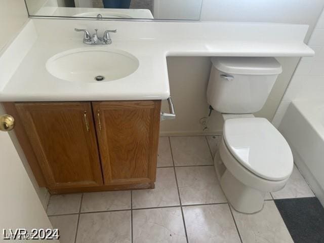 bathroom featuring toilet, vanity, tile patterned floors, and a tub