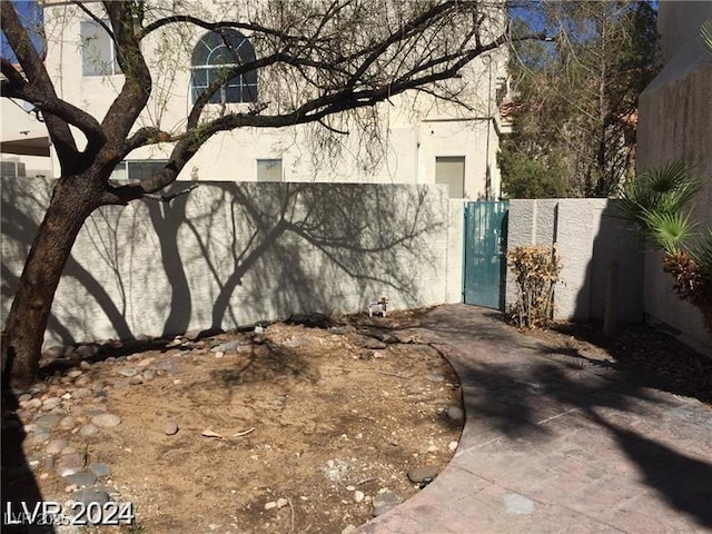view of side of property featuring a gate, stucco siding, and fence