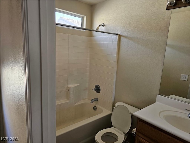 bathroom featuring a textured wall, vanity, washtub / shower combination, and toilet