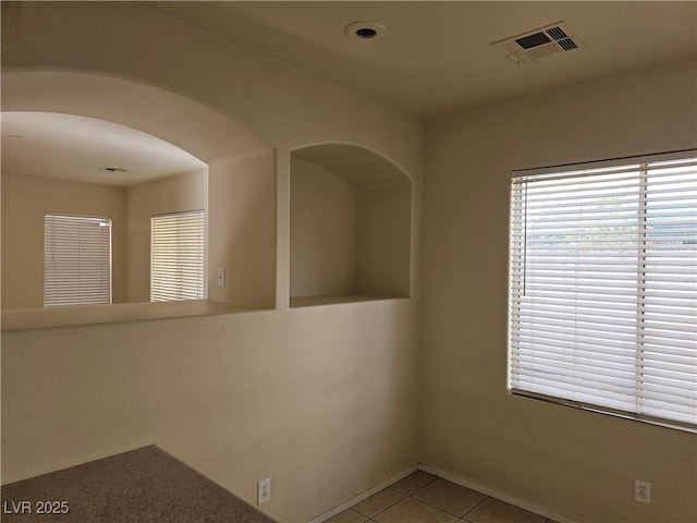 empty room featuring light tile patterned flooring and visible vents