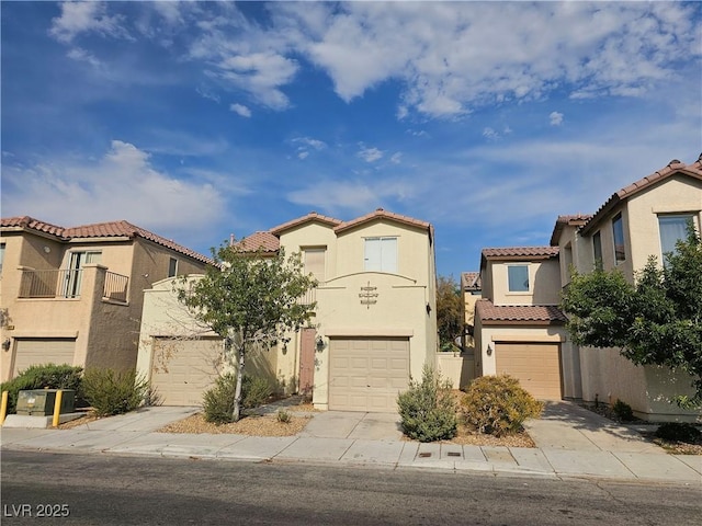mediterranean / spanish home with stucco siding, a tile roof, driveway, and a garage