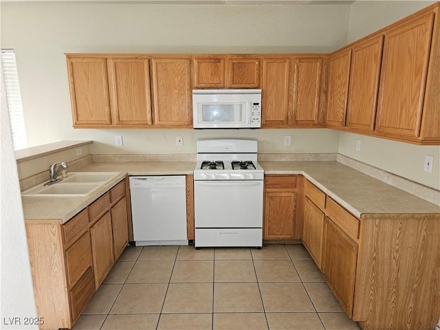 kitchen featuring light countertops, light tile patterned floors, a sink, and white appliances