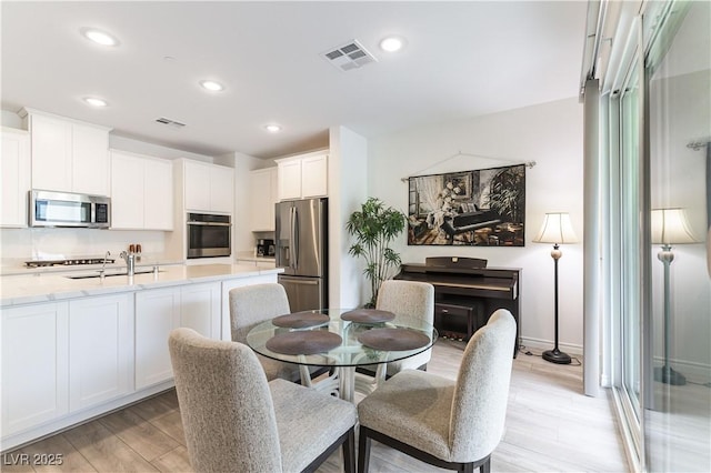 dining space with visible vents, recessed lighting, and light wood-style floors