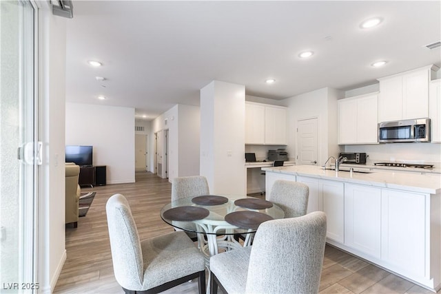 dining area with recessed lighting, light wood finished floors, a toaster, visible vents, and baseboards