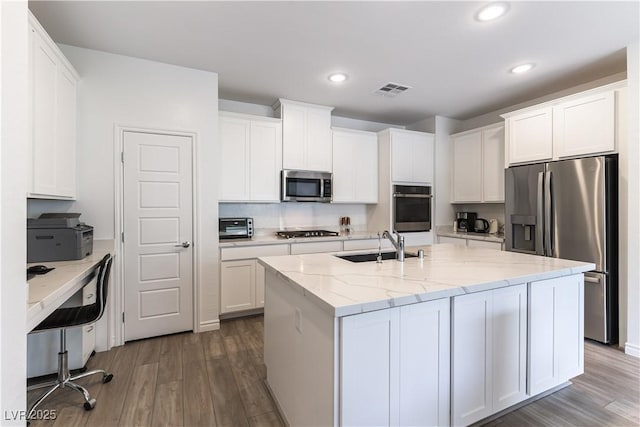 kitchen featuring visible vents, dark wood-style floors, stainless steel appliances, and a sink