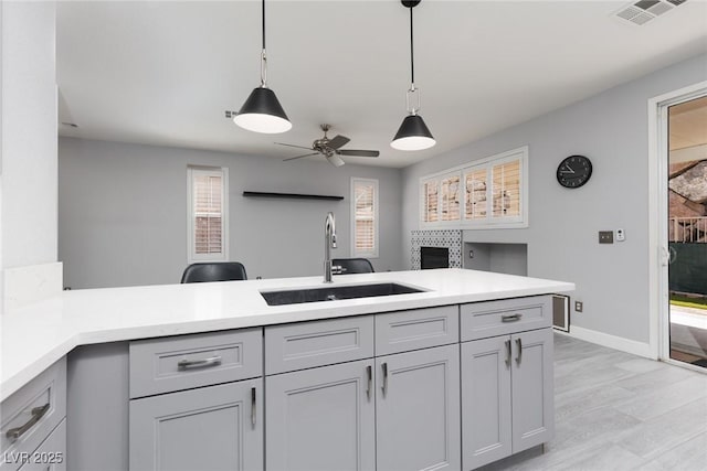 kitchen featuring light countertops, visible vents, a sink, and a ceiling fan