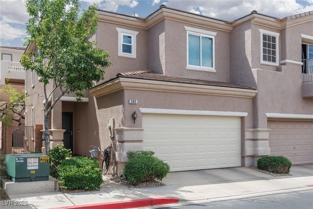 multi unit property with a garage, concrete driveway, and stucco siding