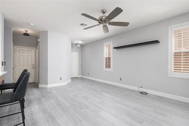 interior space featuring ceiling fan, baseboards, visible vents, and light wood-type flooring