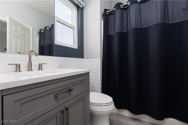full bathroom with toilet, vanity, tile walls, wainscoting, and a shower with shower curtain