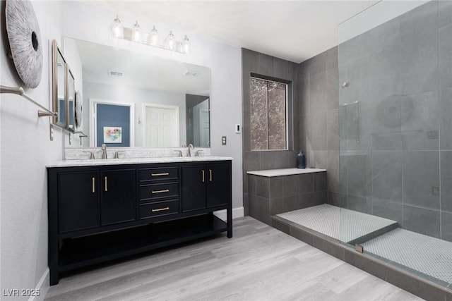 689 Principle Point Ave, Henderson, NV 89012 - bathroom with wood finished floors, tiled shower, double vanity, and baseboards
