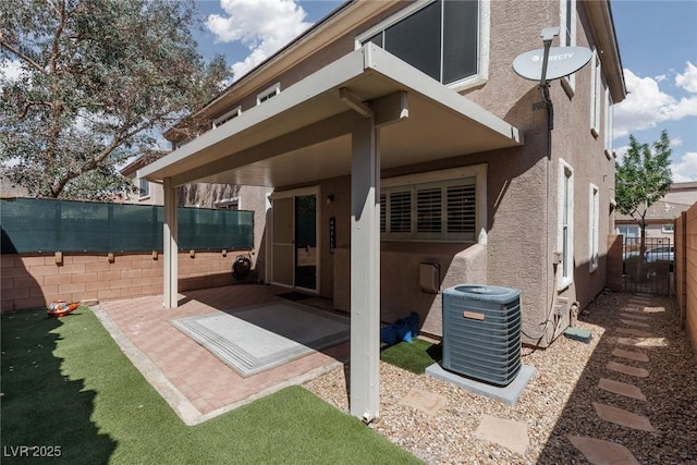 rear view of house featuring central air condition unit, a patio area, a fenced backyard, and stucco siding