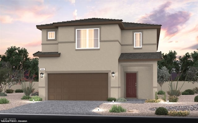 traditional-style home featuring a garage, driveway, and stucco siding