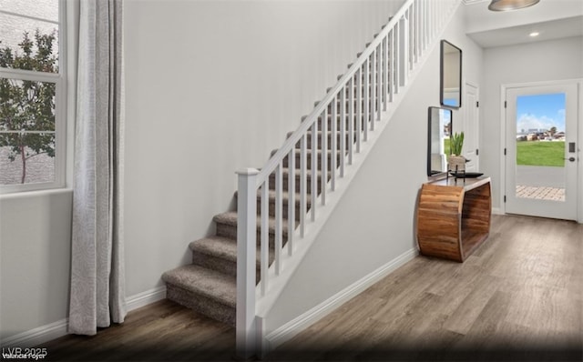 stairway featuring recessed lighting, wood finished floors, and baseboards