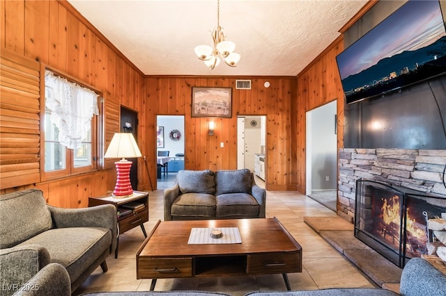 650 Arizona St, Boulder City, NV 89005 - living area with wooden walls, visible vents, an inviting chandelier, and a fireplace