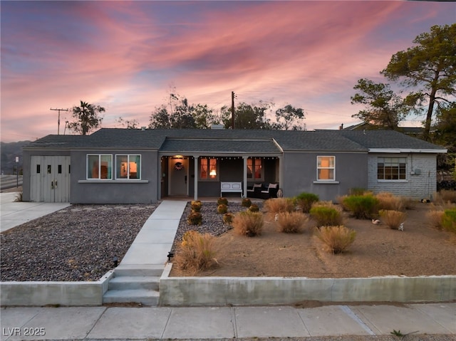 650 Arizona St, Boulder City, NV 89005 - view of front of house featuring stucco siding, an attached garage, a porch, and concrete driveway
