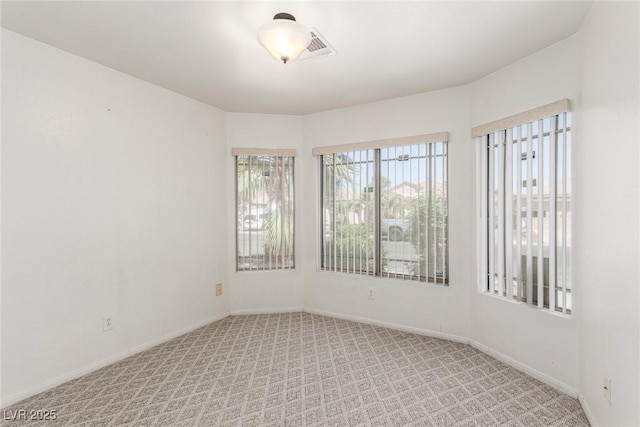 carpeted spare room featuring baseboards