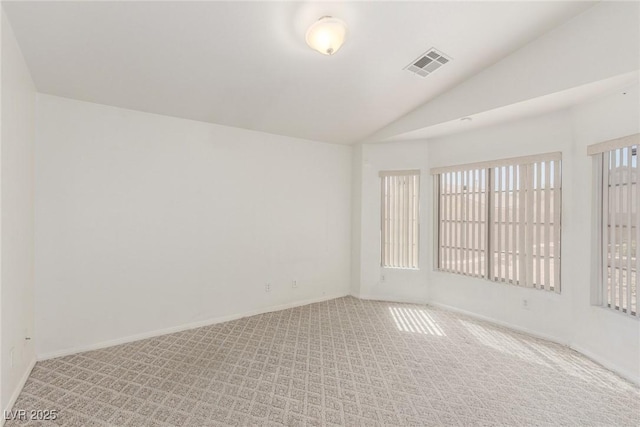 unfurnished room with light colored carpet, lofted ceiling, visible vents, and baseboards