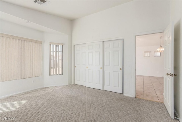 unfurnished bedroom with baseboards, a closet, visible vents, and carpet