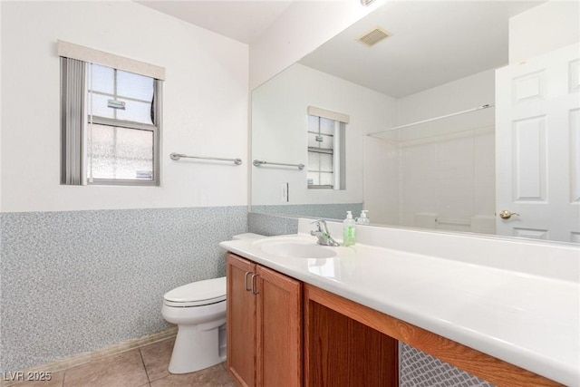 bathroom featuring tile patterned flooring, visible vents, toilet, vanity, and walk in shower