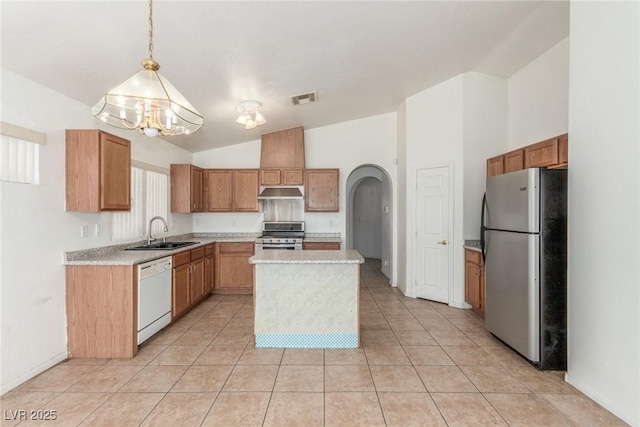 kitchen featuring an inviting chandelier, light countertops, a sink, arched walkways, and appliances with stainless steel finishes