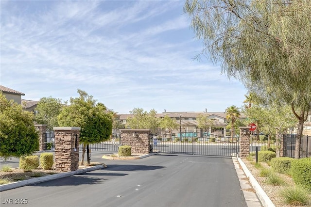 6247 Milford Sound St, Las Vegas, NV 89148 - view of asphalt street with a gate, curbs, a gated entry, and traffic signs