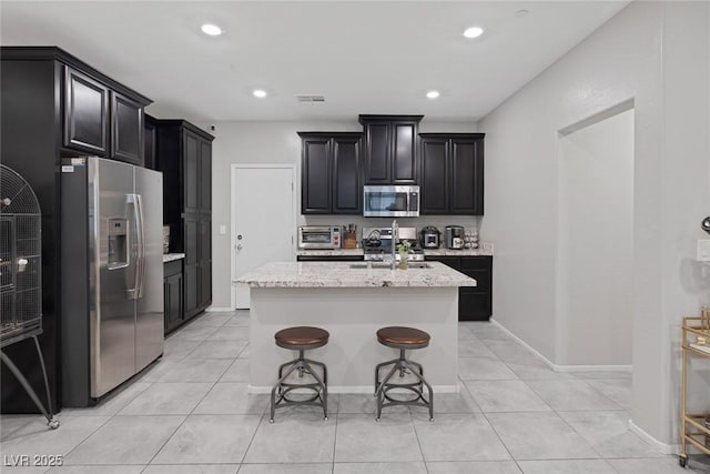 6247 Milford Sound St, Las Vegas, NV 89148 - kitchen with stainless steel appliances, dark cabinets, a sink, light stone countertops, and recessed lighting