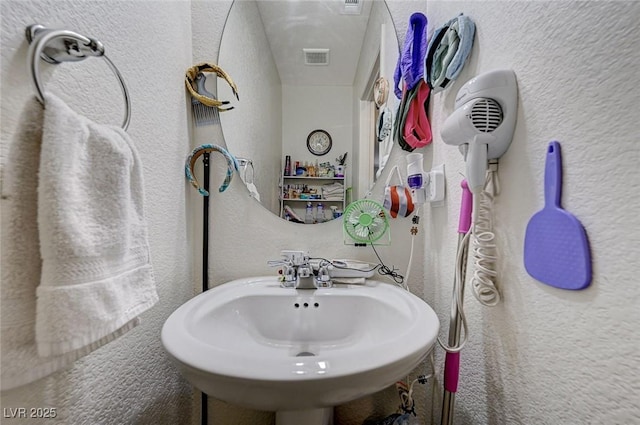 8783 Halcon Ave, Las Vegas, NV 89148 - bathroom featuring a textured wall, a sink, and visible vents