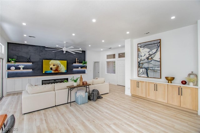10709 Hunters Woods Pl, Las Vegas, NV 89134 - living room featuring recessed lighting, light wood-style floors, an accent wall, a ceiling fan, and baseboards