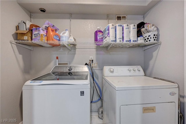 washroom with visible vents and separate washer and dryer