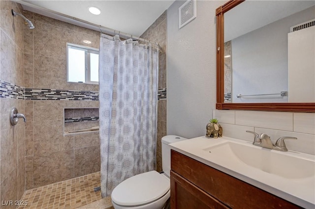 full bathroom featuring visible vents, a stall shower, toilet, and vanity