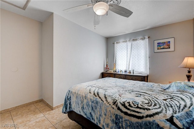 bedroom with light tile patterned floors, a ceiling fan, and baseboards