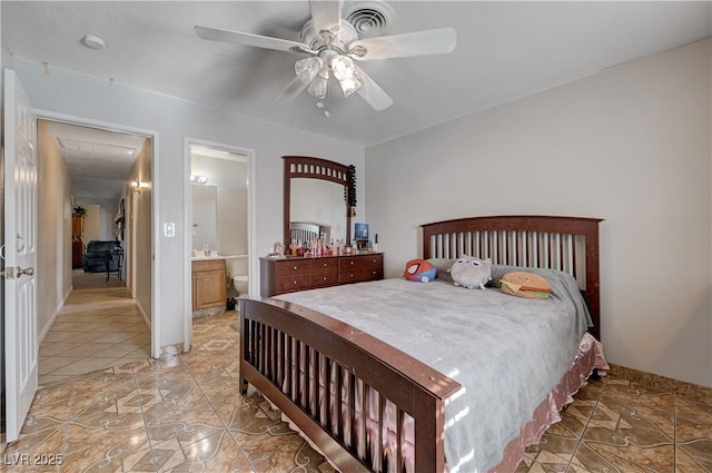 bedroom featuring connected bathroom, light tile patterned floors, attic access, visible vents, and a ceiling fan