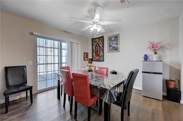 dining space with baseboards, visible vents, wood finished floors, and a ceiling fan