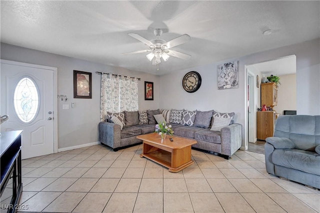 living room featuring light tile patterned floors, ceiling fan, and baseboards