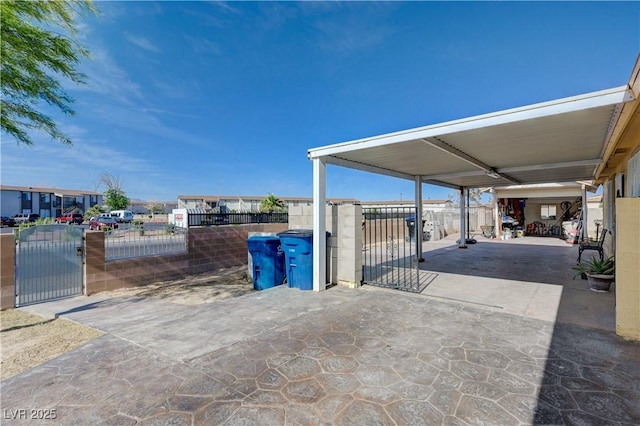view of patio with fence, a gate, and a carport