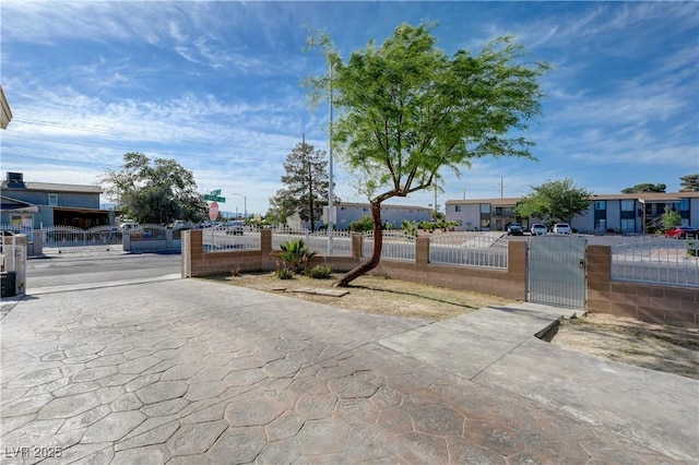 view of front facade with a gate, a residential view, and a fenced front yard