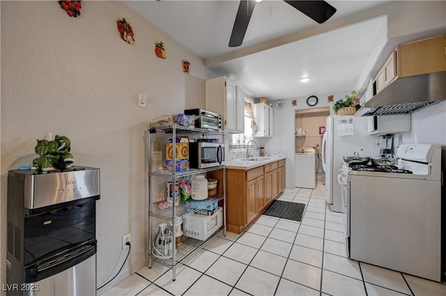 kitchen featuring white gas range oven, stainless steel microwave, a sink, ceiling fan, and light countertops