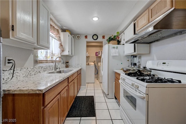 kitchen with a sink, independent washer and dryer, under cabinet range hood, white appliances, and light countertops