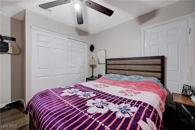 bedroom with visible vents, wood finished floors, ceiling fan, and a closet