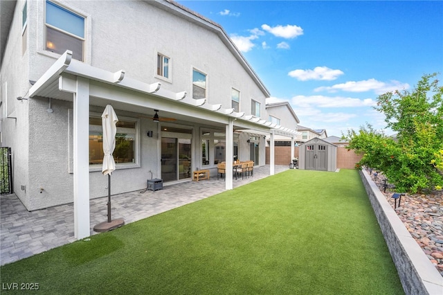 7307 Grace Estate Ave, Las Vegas, NV 89113 - back of property with a storage unit, an outbuilding, a lawn, a patio, and stucco siding