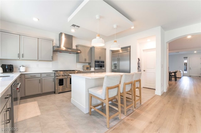 7307 Grace Estate Ave, Las Vegas, NV 89113 - kitchen with wall chimney range hood, gray cabinets, premium appliances, and visible vents