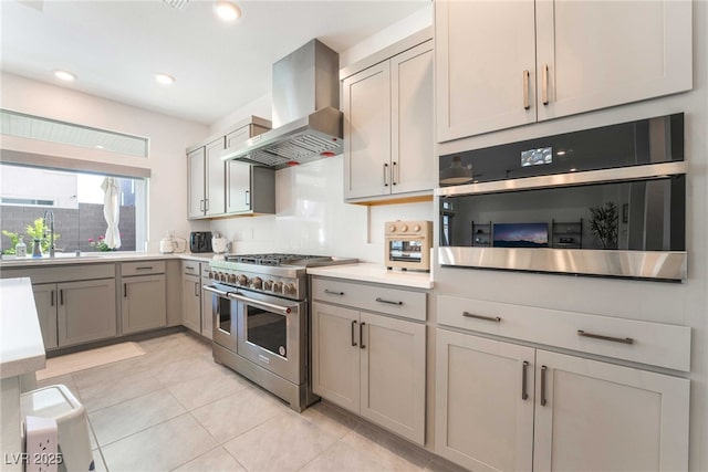 7307 Grace Estate Ave, Las Vegas, NV 89113 - kitchen featuring wall chimney range hood, gray cabinets, light tile patterned floors, a sink, and appliances with stainless steel finishes