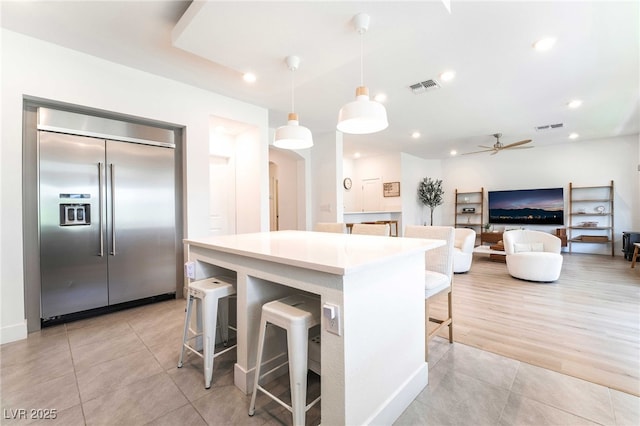 7307 Grace Estate Ave, Las Vegas, NV 89113 - kitchen with arched walkways, stainless steel built in fridge, visible vents, and light tile patterned flooring